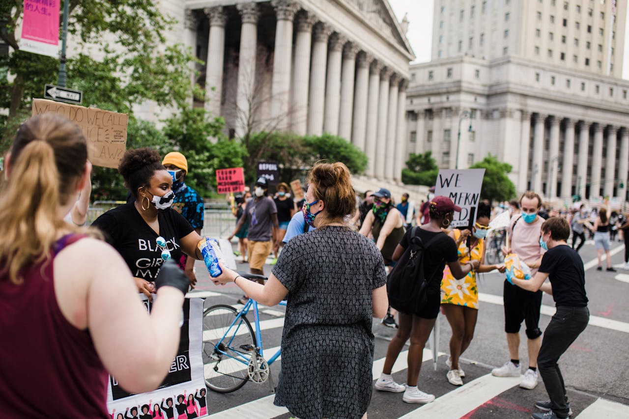 Participants join a peaceful protest advocating for justice and equality in an urban setting with iconic architecture.