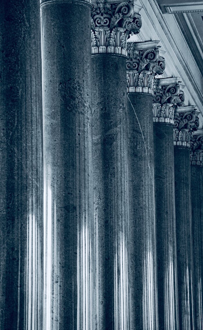hero-img-01 Artistic monochrome shot of Corinthian columns showcasing architectural elegance and grandeur.